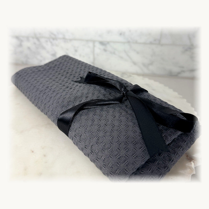 Grey textured kitchen cloth bundle tied with a black satin ribbon